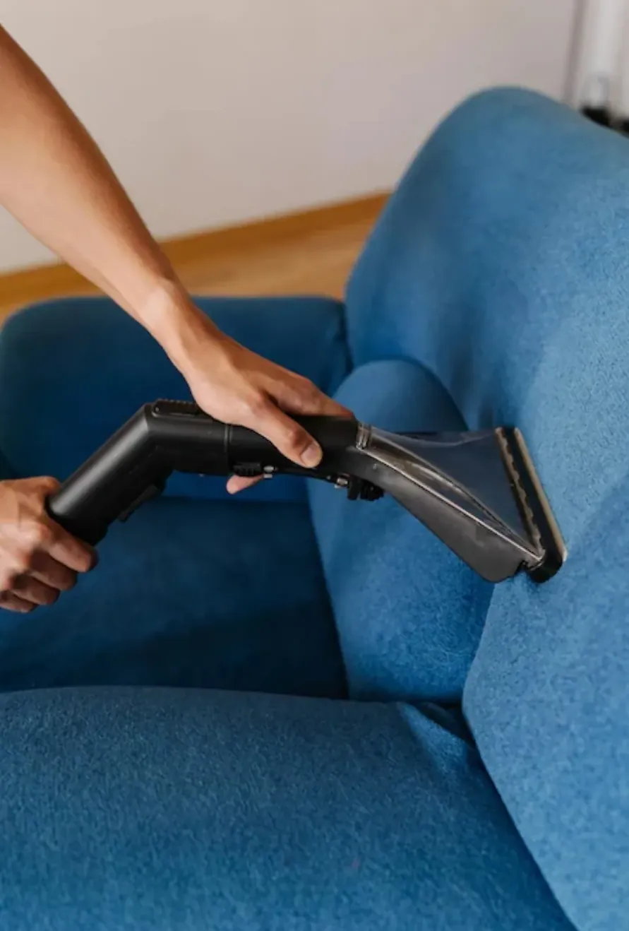 Boquilla de extracción limpiando el tapiz de un sillón azul